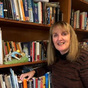 Image of Julie Faulkner with shelf of books.