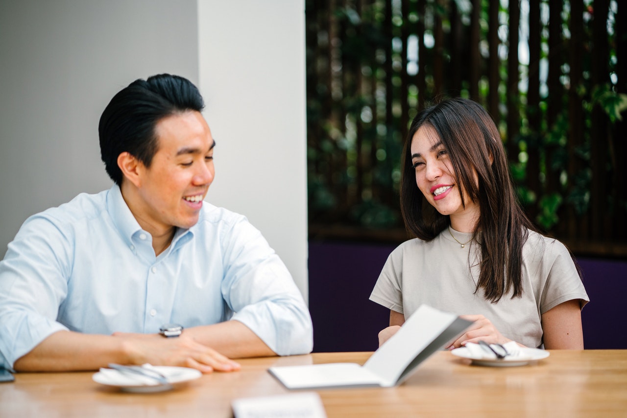 Man and woman at table with notebook.