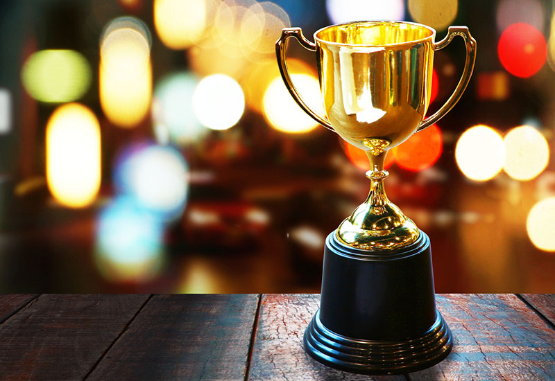 IPEd awards and prizes Trophy on timber table