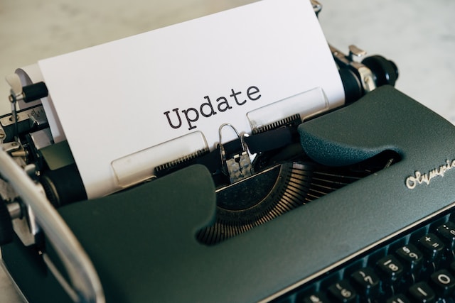 A white piece of paper with the word "update" is in an old-fashioned green typewriter.