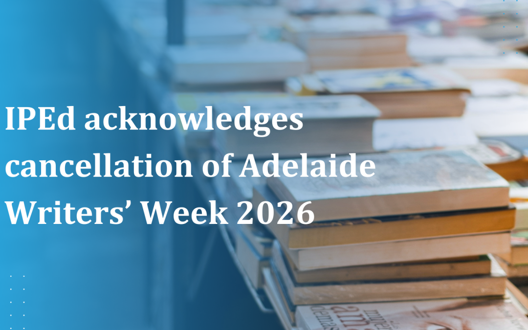 Stacks of books laid out on long tables at a book market or literary event.